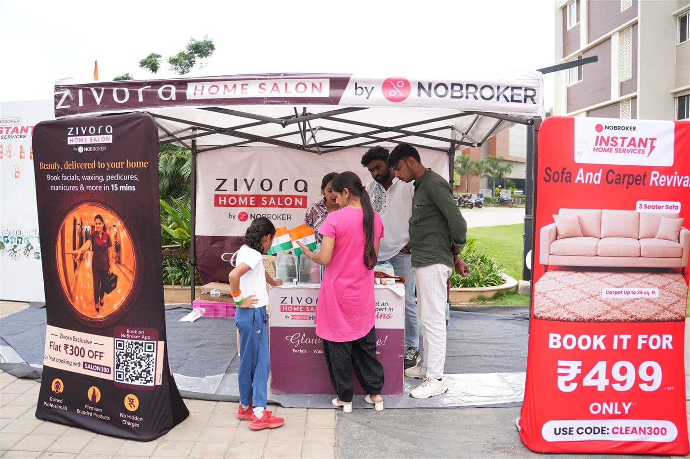 Resident family with tricolor flags at the Zivora Home Salon booth during the 15th August activation