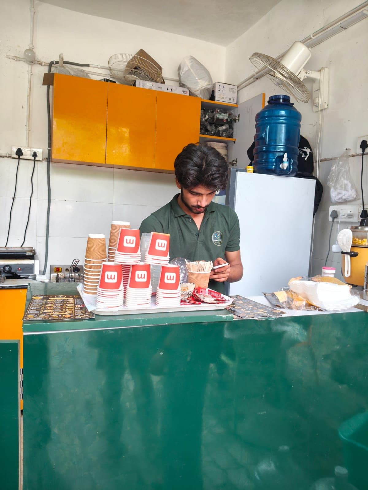 Corporate office pantry counter stocked with RentoMojo-branded cups