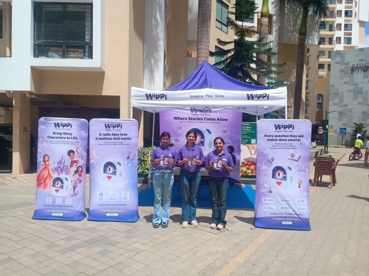 Wippi team and branded gazebo with "Where Stories Come Alive" banner at a Bengaluru RWA