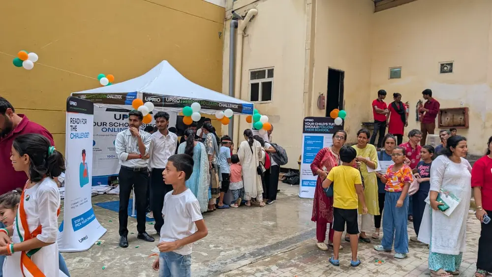 Wide view of the UPRIO Freedom to Learn Challenge activation in Delhi with children, parents and branded banners around the tent