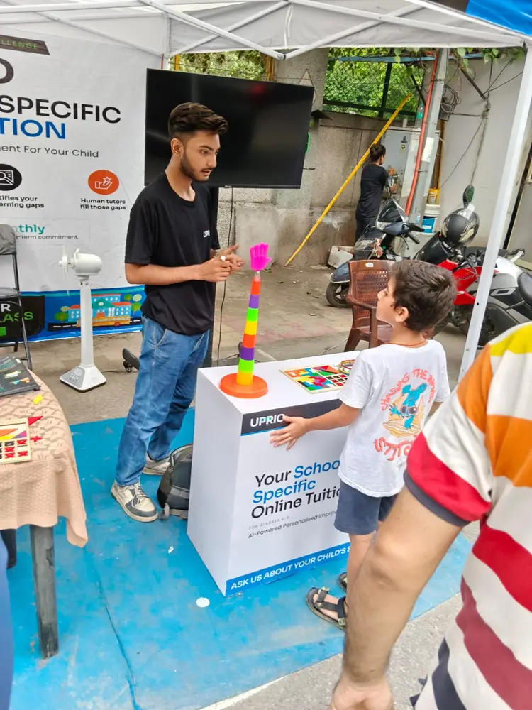 UPRIO promoter explaining a game to a child at a game station during the activation